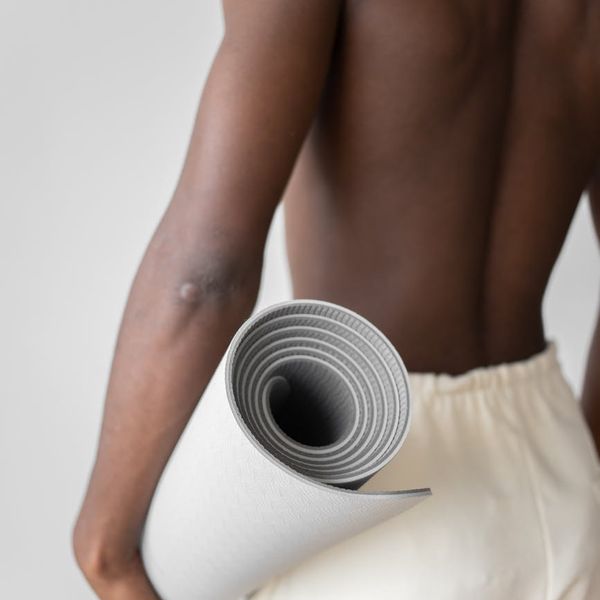 Focused man performing a core strength exercise on a mat in a serene setting.