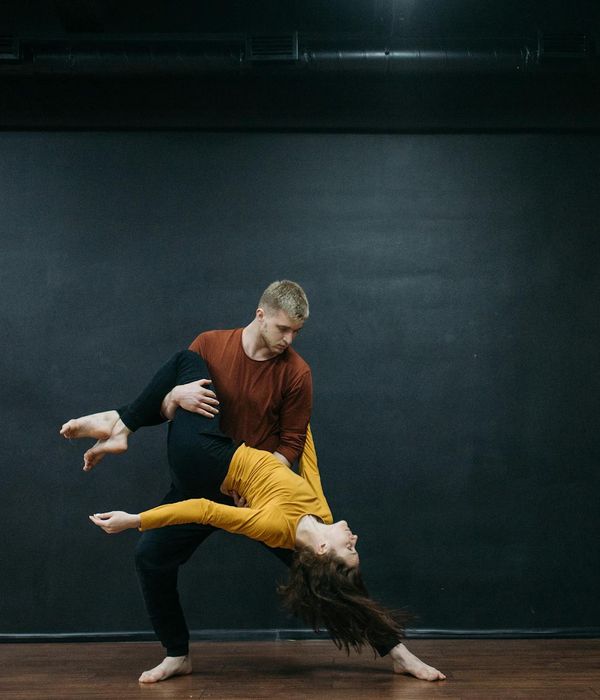 Man demonstrating a strength and balance pose in a bright, modern studio.
